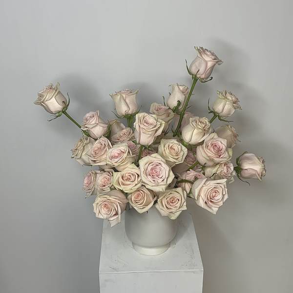 Bouquet of pale pink roses in a white vase