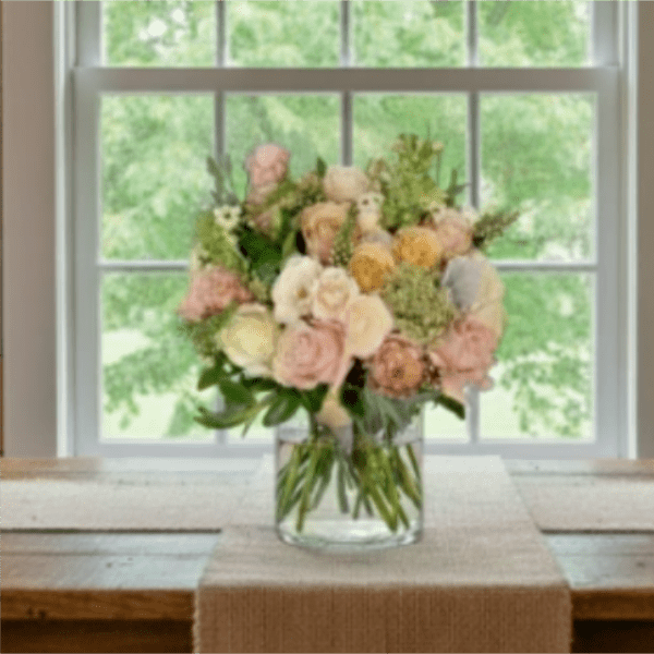 Pastel rose bouquet in a clear glass vase on a table