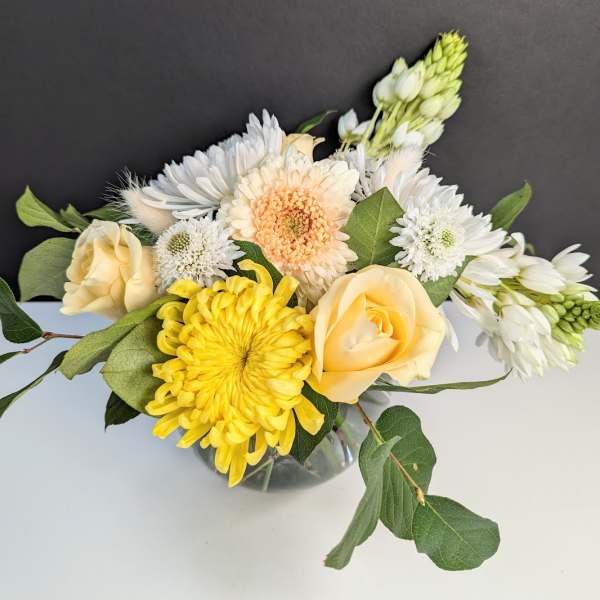 Yellow and white mixed flowers in a glass vase