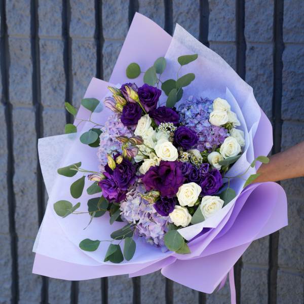 Bouquet of purple and white roses with lavender hydrangeas