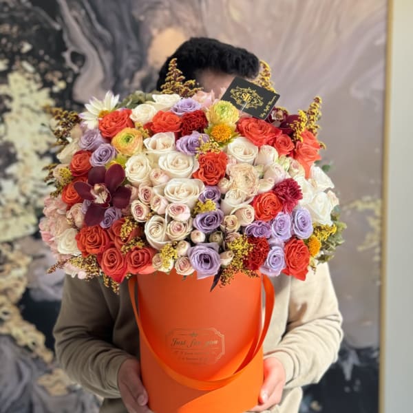 Large mixed rose bouquet in an orange hatbox