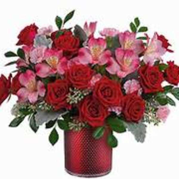 Red roses and pink alstroemeria in a red vase