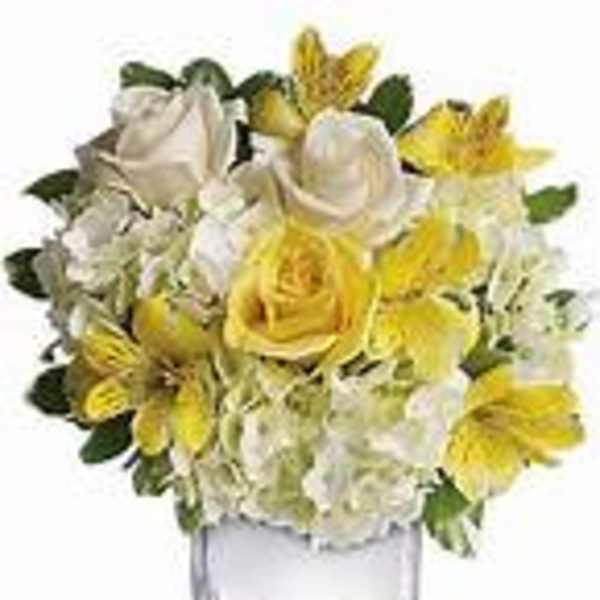 Yellow and white flower arrangement in a clear glass vase