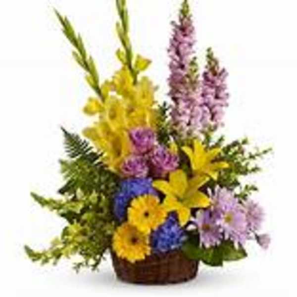 Basket arrangement with yellow lilies, purple flowers, and blue daisies