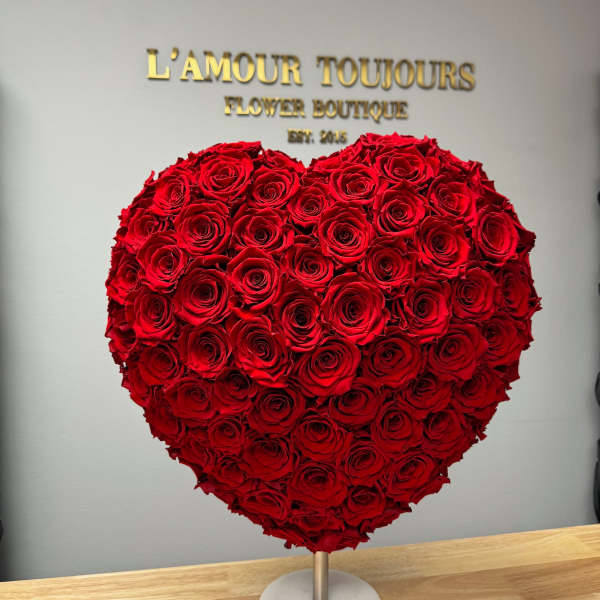 Heart-shaped arrangement of red roses on a stand