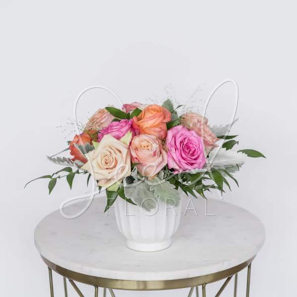 Mixed roses in a white vase on a round table