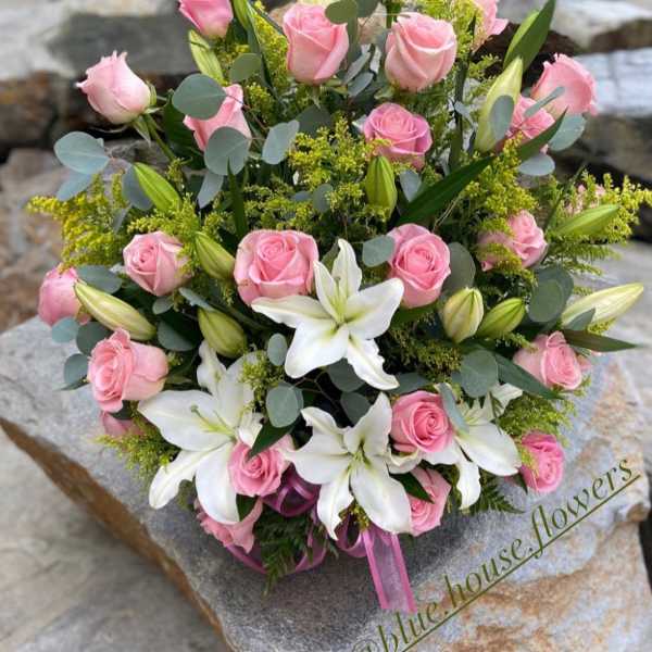 Pink roses and white lilies arranged in a bouquet
