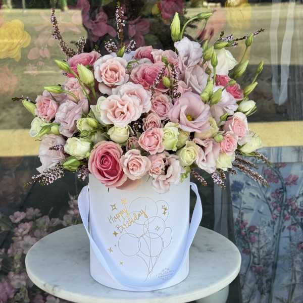 Pink and white roses in a white gift box with a ribbon handle