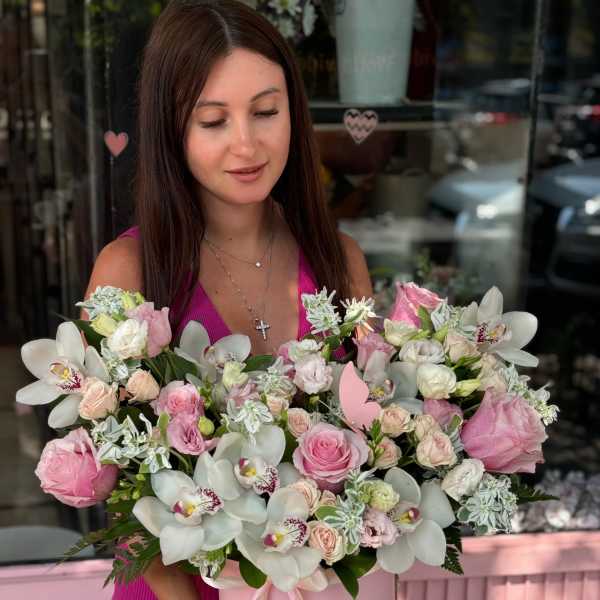 Woman holding a pink box of pink and white flowers