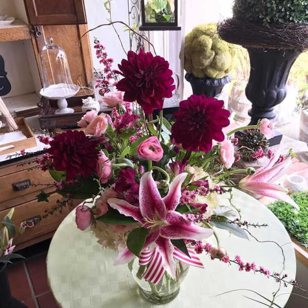 Pink lilies and dark magenta dahlias in a glass vase