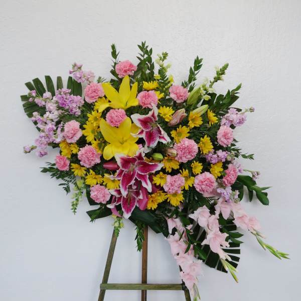 Standing floral spray with pink, yellow, and white blooms on an easel