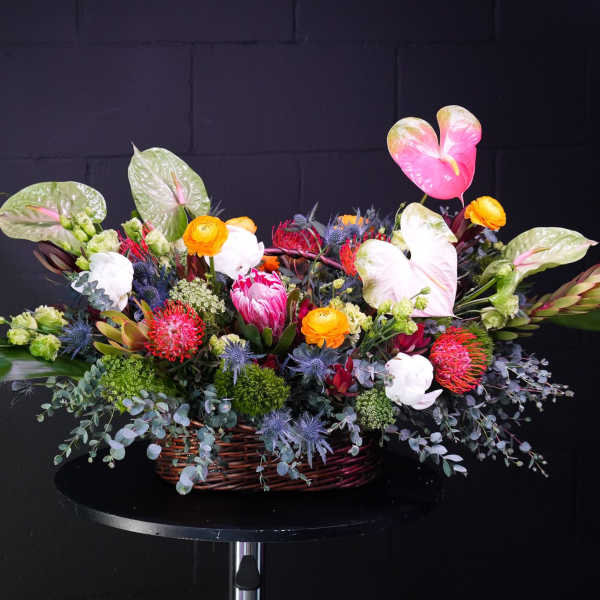 Colorful mixed flower arrangement in a wicker basket