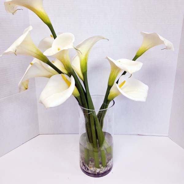 White calla lilies in a clear glass vase