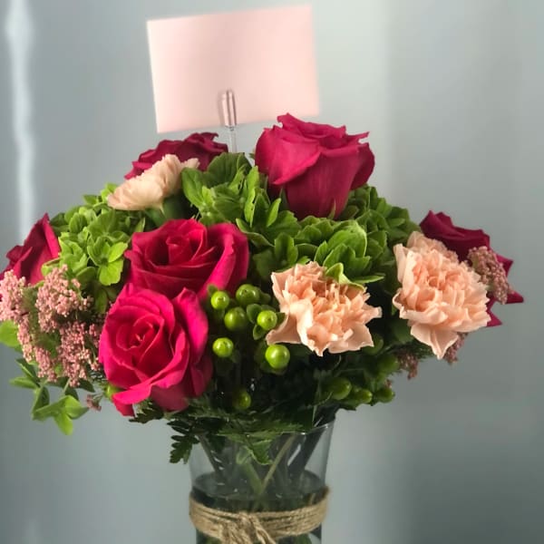 Pink roses and peach carnations in a glass vase