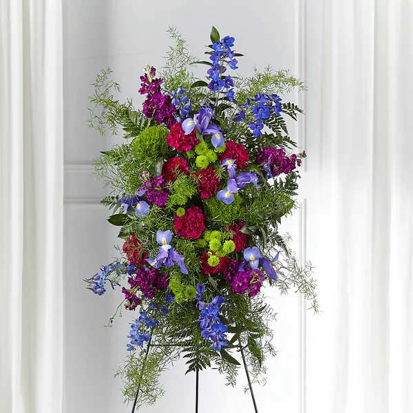 Tall standing floral spray with blue, purple, and pink flowers