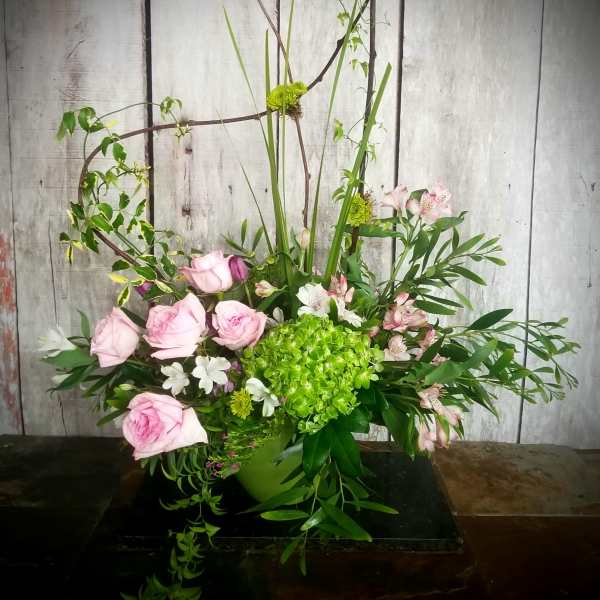 Pink roses and green hydrangea in a low vase arrangement