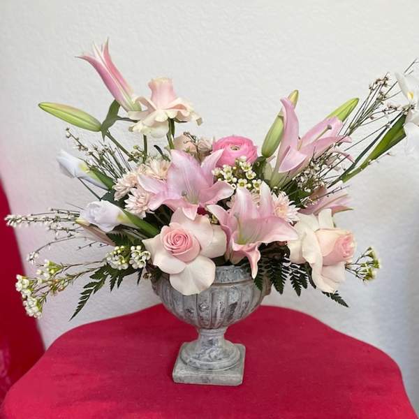 Pink and white floral arrangement in a gray urn vase