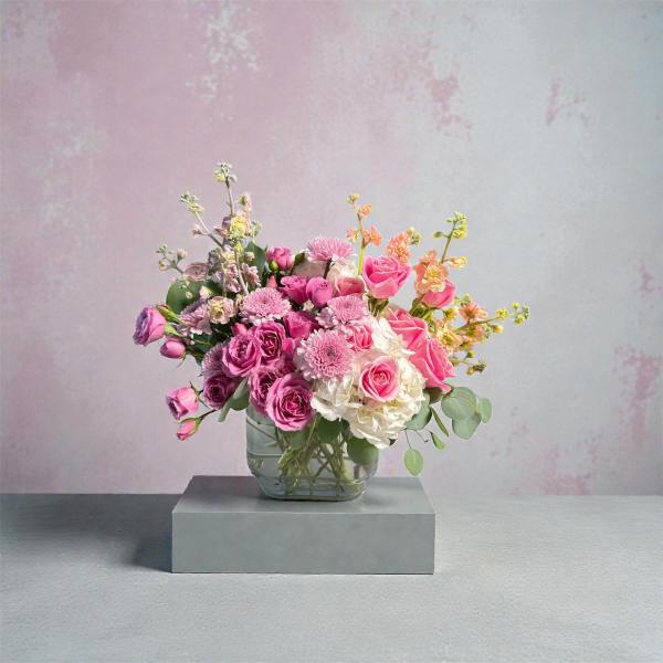 Pink and white mixed flower arrangement in a clear glass vase