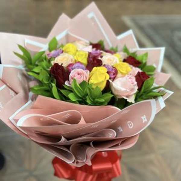 Bouquet of multicolored roses wrapped in pink paper