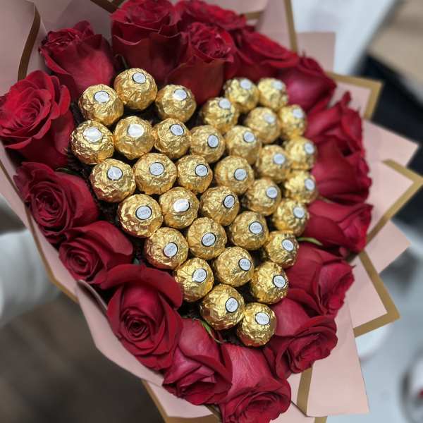 Heart-shaped bouquet of red roses with gold-wrapped chocolates