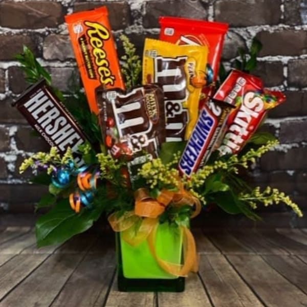 Candy bars arranged in a gift bouquet with ribbon in a green container