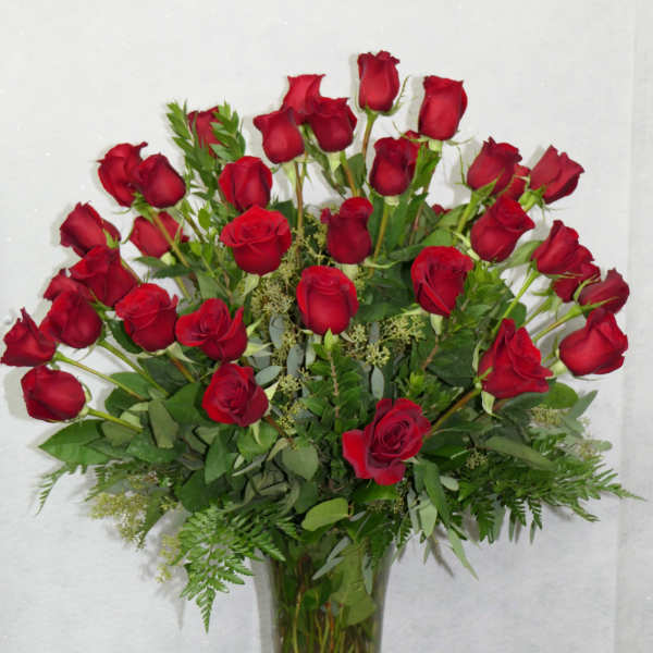 Red roses arranged in a clear glass vase