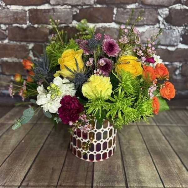 Colorful mixed flower arrangement in a patterned vase