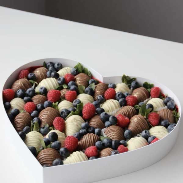 Heart-shaped box filled with chocolate-covered strawberries, raspberries, and blueberries