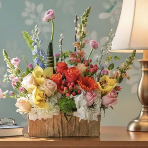 Mixed bouquet in a wooden box with roses and orchids