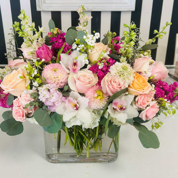 Mixed pink and white floral arrangement in a clear glass vase