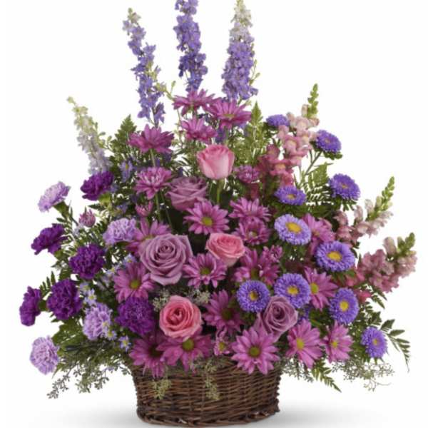 Purple and pink mixed flower basket in a wicker container