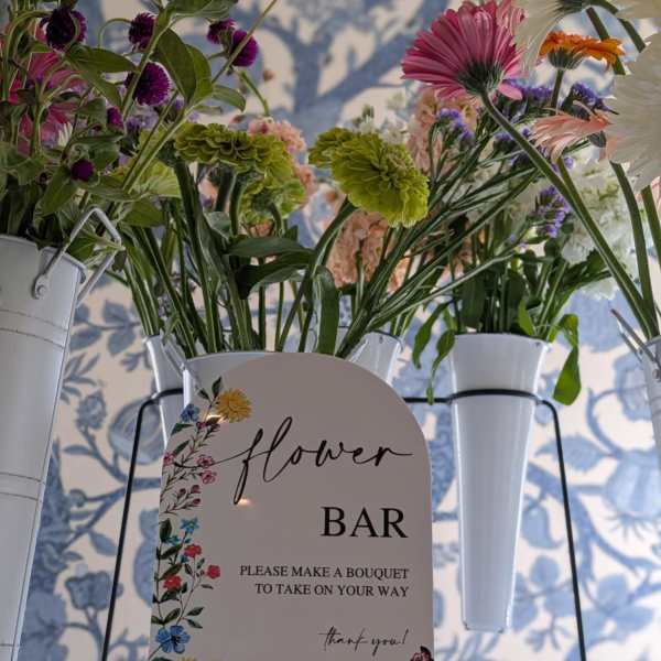 Flower bar display with mixed bouquets in white metal buckets