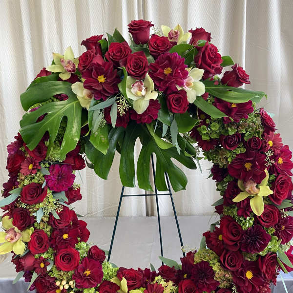 Heart-shaped floral wreath with red roses and burgundy blooms