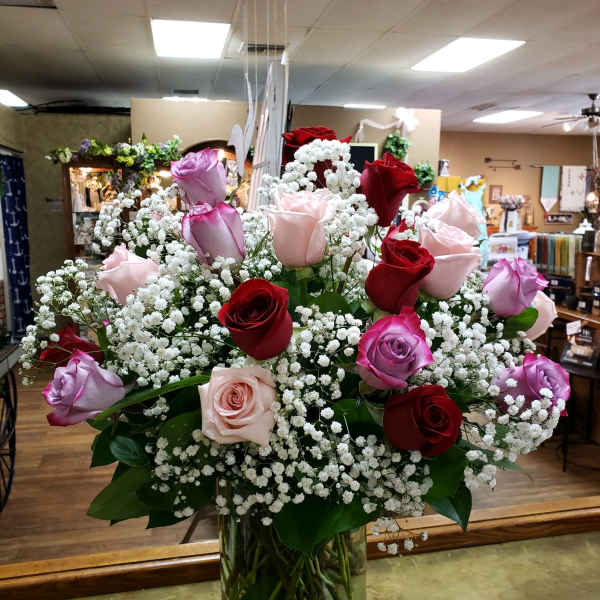 Bouquet of red, pink, and lavender roses in a glass vase
