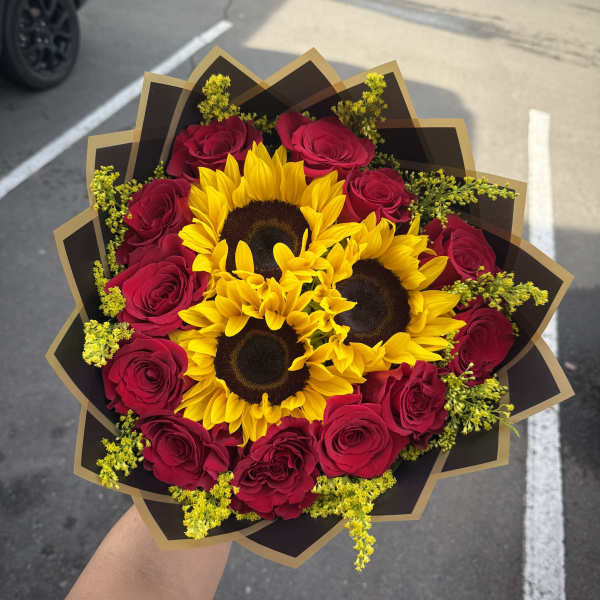 Bouquet of red roses and sunflowers wrapped in black paper