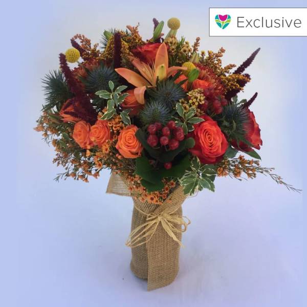 Bouquet of orange and red flowers wrapped in burlap