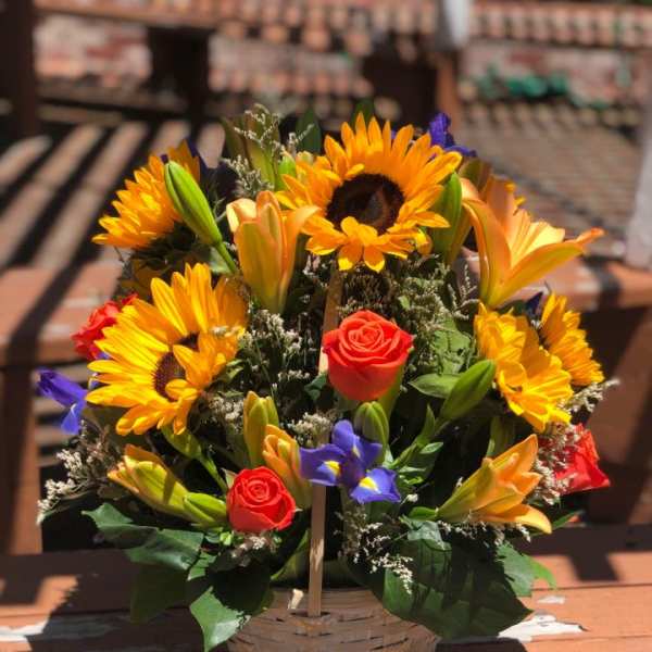 Basket arrangement with sunflowers, roses, and lilies