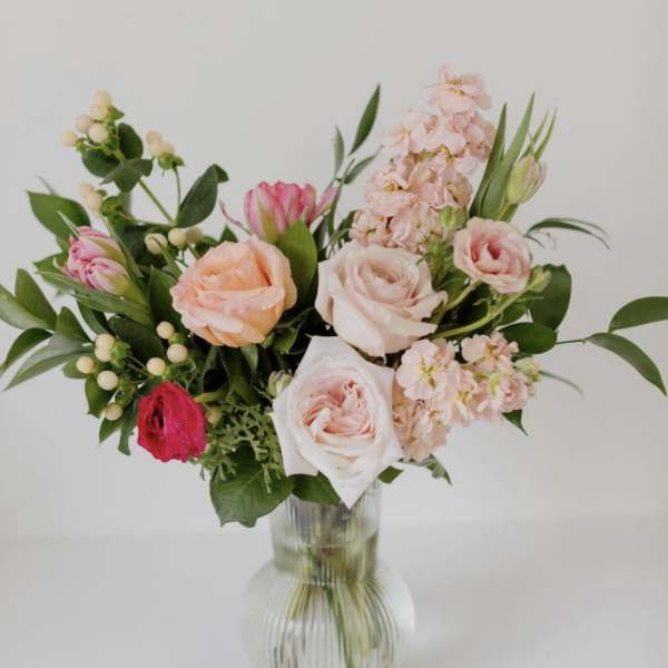 Bouquet of pink and peach roses in a clear glass vase