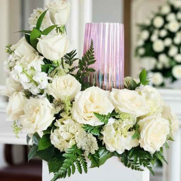 White rose arrangement with a pink glass vase centerpiece