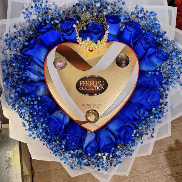 Heart-shaped bouquet with blue roses and a Ferrero Rocher box in the center