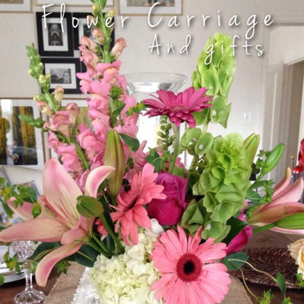 Pink and green floral arrangement in a vase with lilies and gerbera daisies