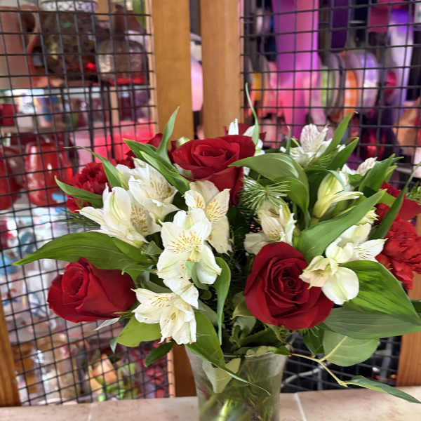 Red roses and white alstroemeria in a clear glass vase