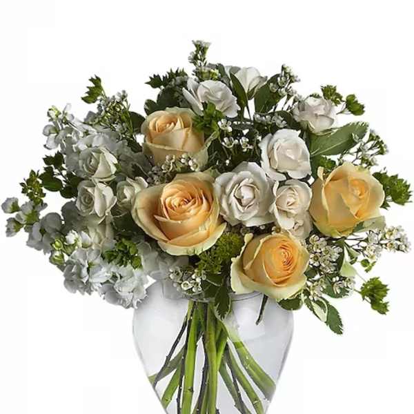 Bouquet of cream and white roses in a clear glass vase