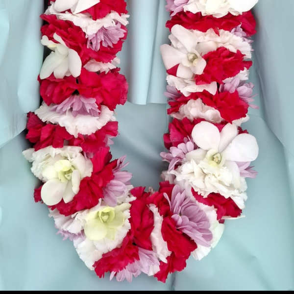 Flower lei made of red, white, and lavender blooms