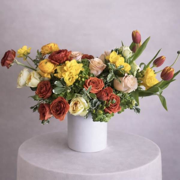 Mixed bouquet of roses and tulips in a white vase