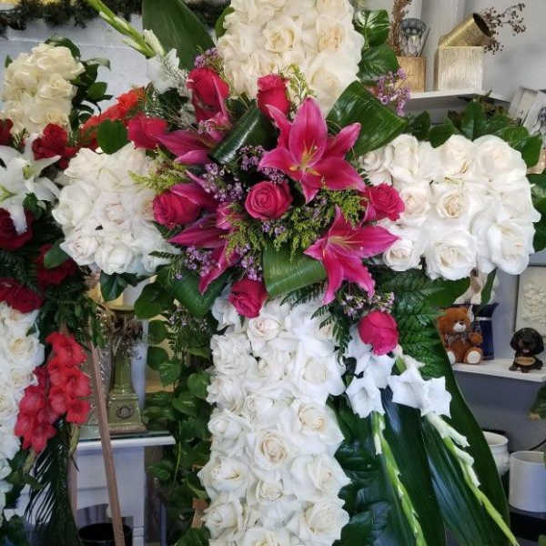Large floral cross of white roses with pink lilies and roses
