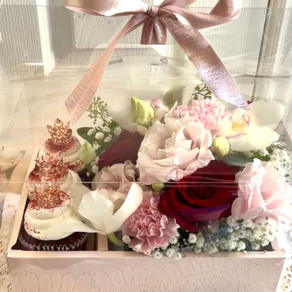 Pink and white floral gift box with cupcakes under a clear lid and ribbon