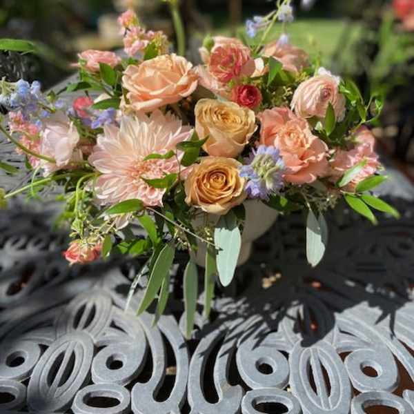 Pastel bouquet of roses and dahlias in a low vase