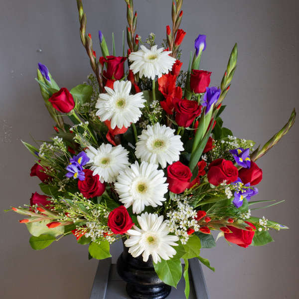 Red roses and white daisies in a black vase