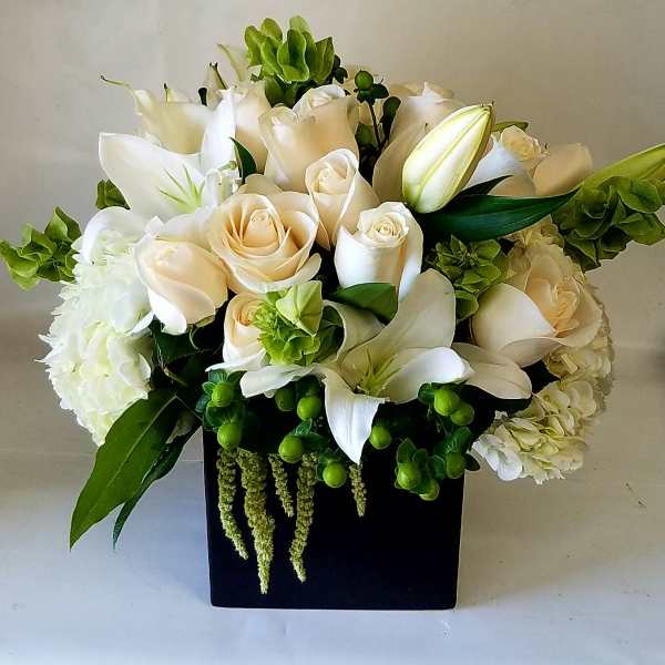 White and cream bouquet in a black square vase